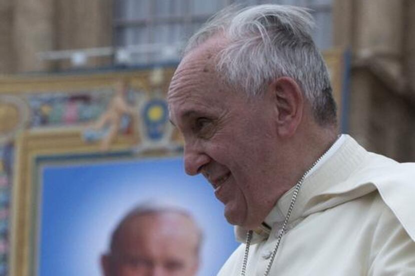 
Pope Francis passes by a tapestry depicting late Pope John Paul II as he leaves at the end...