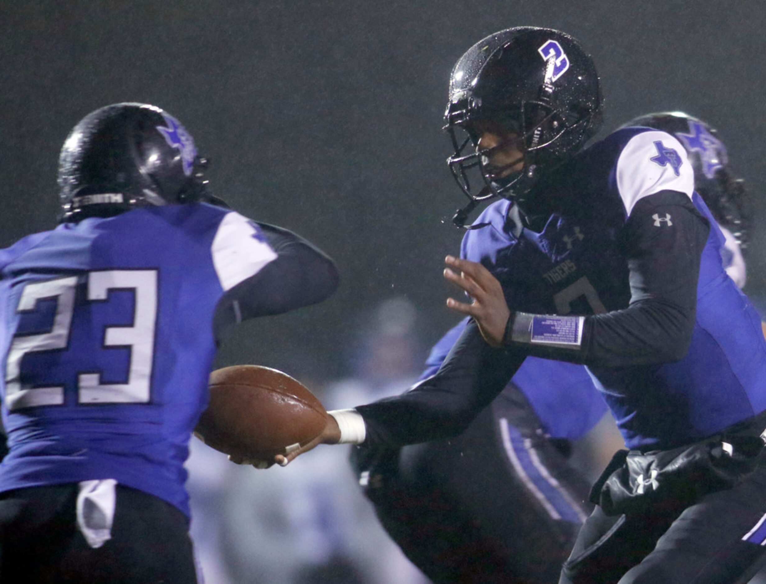 Trinity Christian-Cedar Hill quarterback Shedeur Sanders (2) hands the ball off to running...