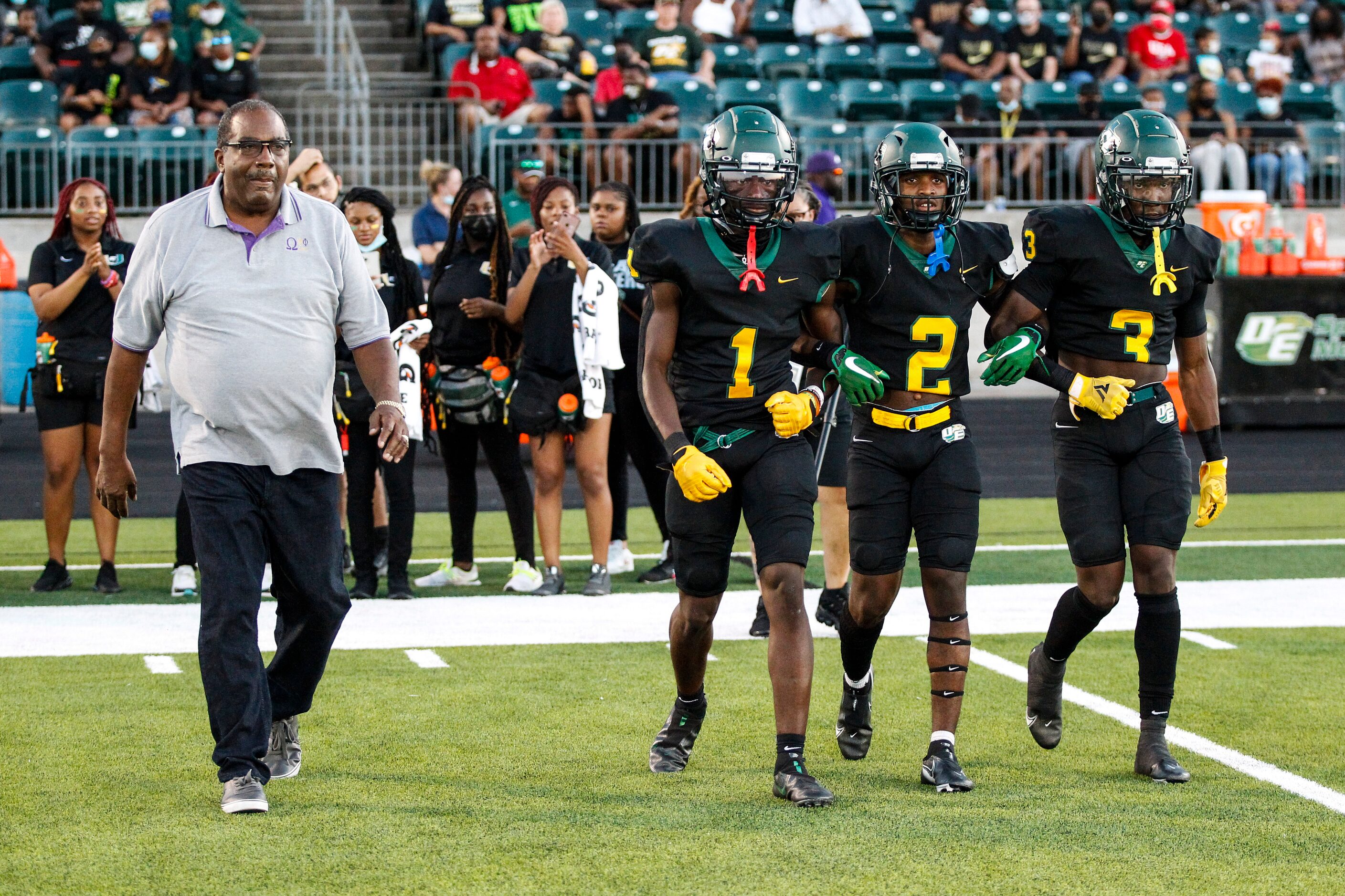 State Senator Royce West, left, walks to center field with DeSoto junior wide receiver...