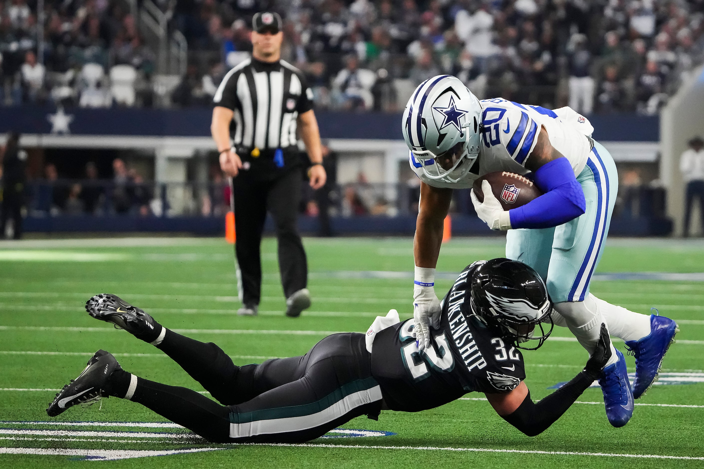 Dallas Cowboys running back Tony Pollard (20) is tripped up by Philadelphia Eagles safety...