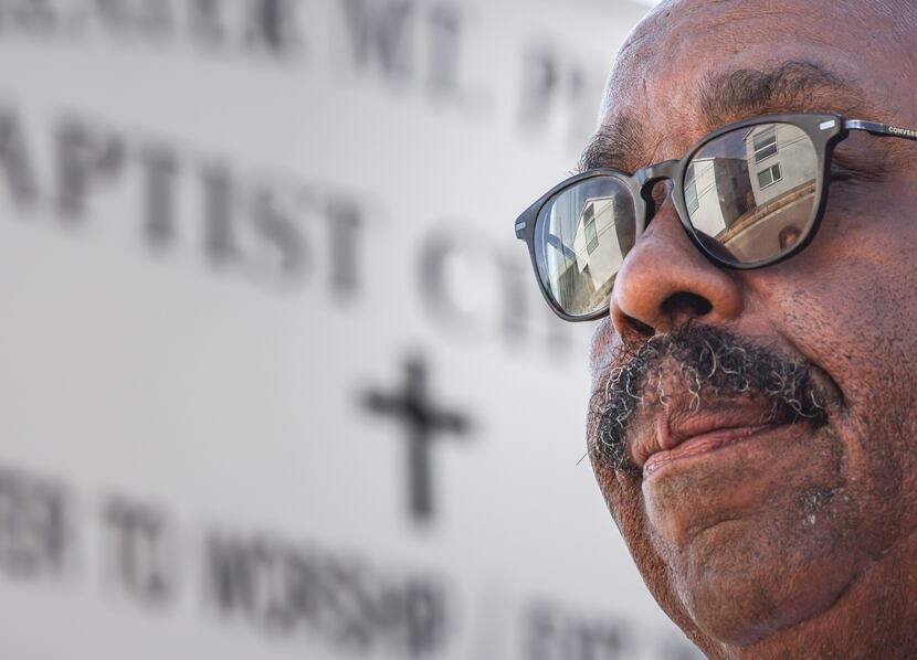 New homes reflected in the glasses of the Rev. Ned Armstrong as he stood outside Greater...