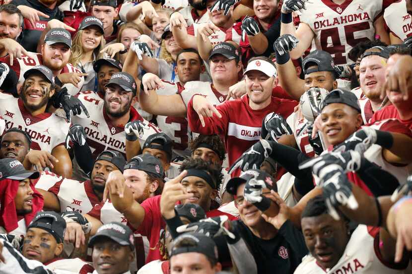 Oklahoma Sooners head coach Lincoln Riley and his players give the horns down hand signal...