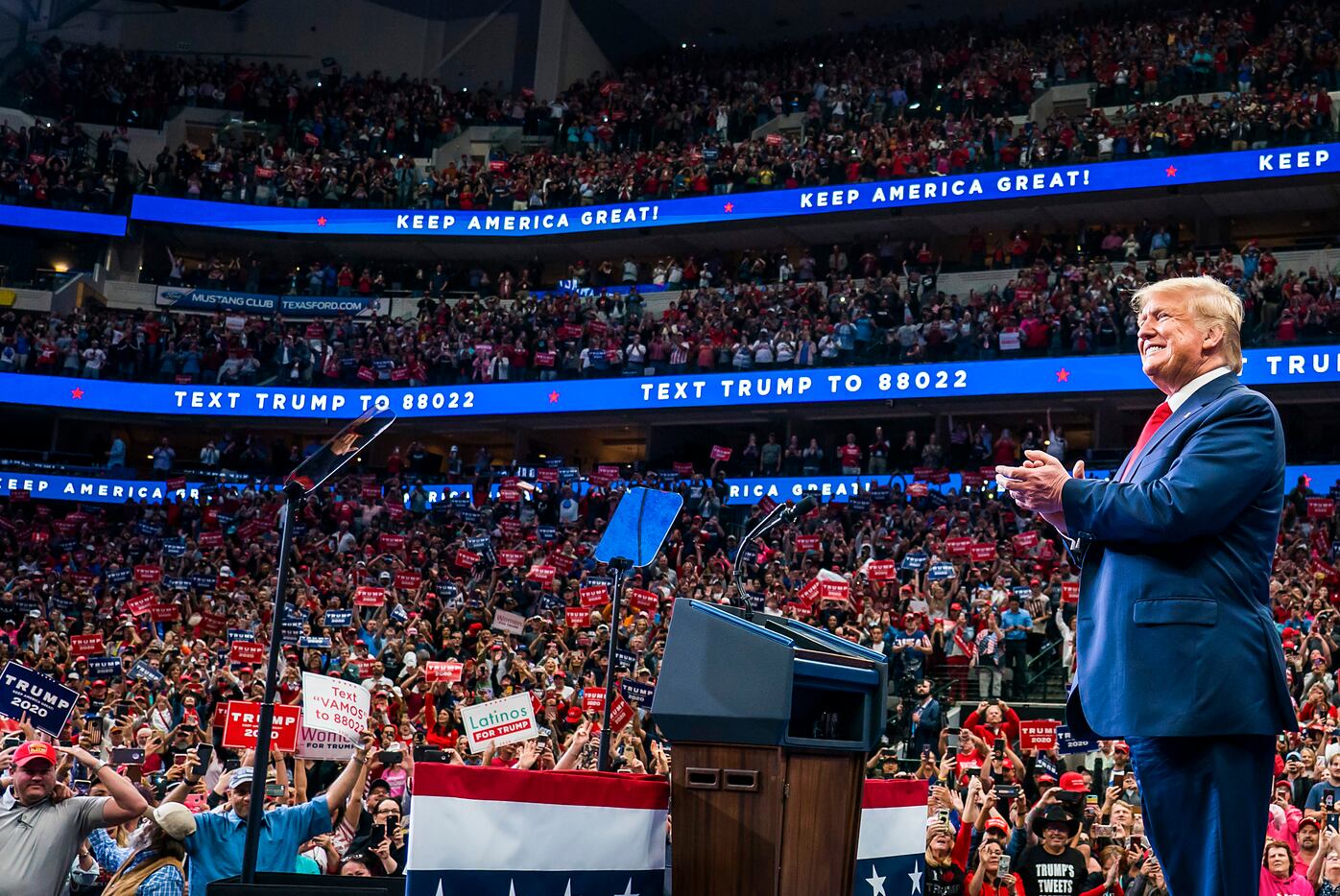 President Donald Trump smiley as he walks to the podium to the cheers of the crowd at the...