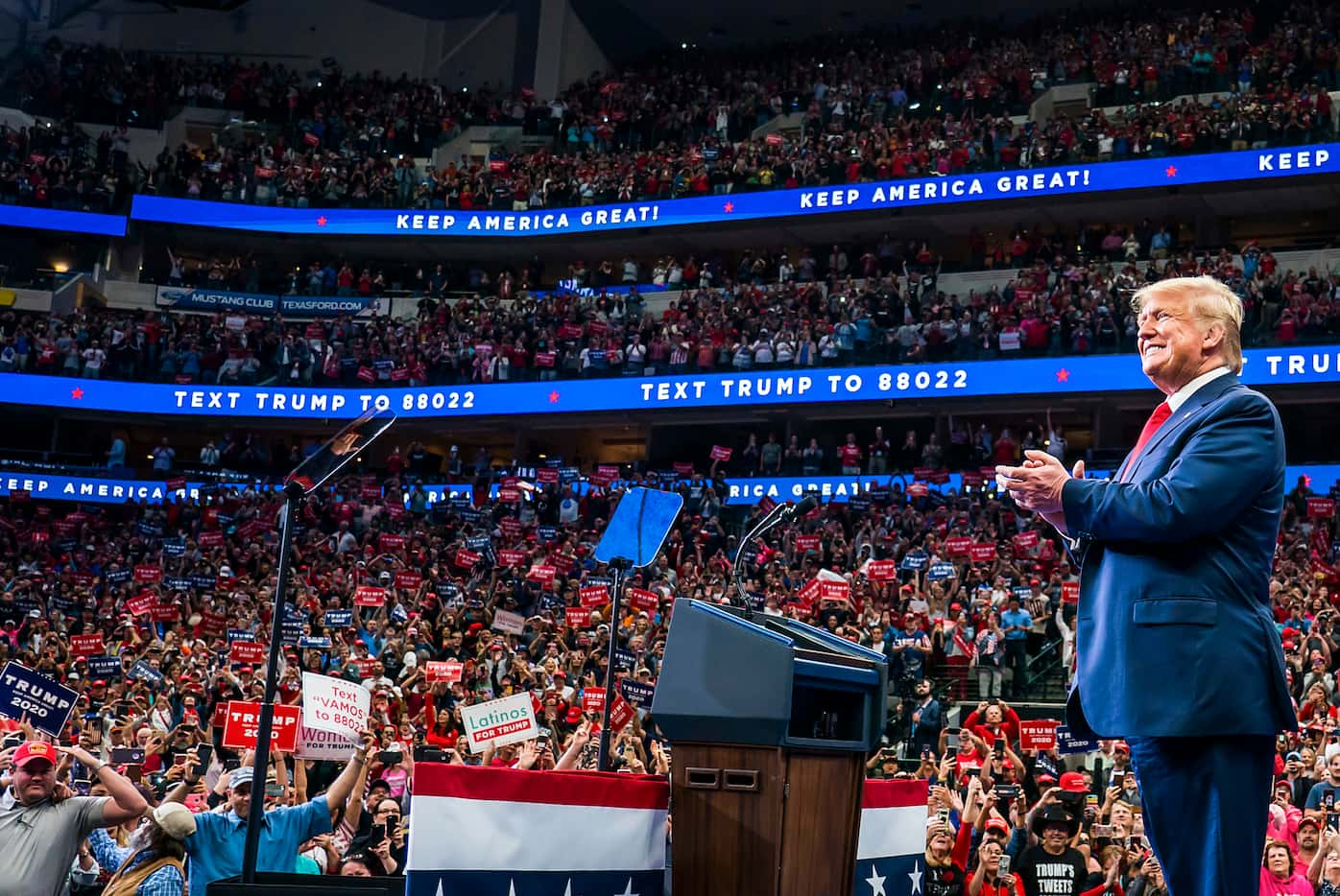 President Donald Trump smiley as he walks to the podium to the cheers of the crowd at the...