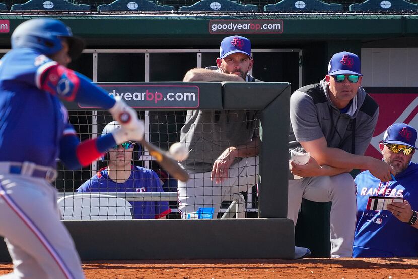 Texas Rangers manager Chris Woodward center) and bench coach/offensive coordinator Donnie...