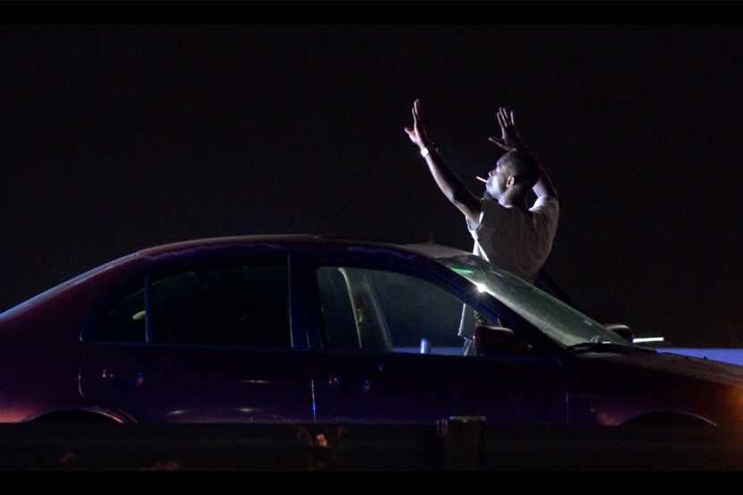 A suspect holds up his hands before he was taken into custody after leading law enforcement...
