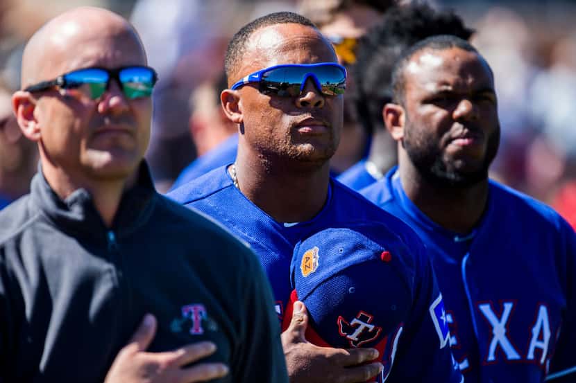 Texas Rangers third baseman Adrian Beltre (29, center) and other players stand for the...