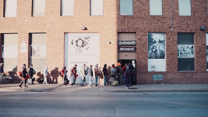 Line of people in need outside a public community kitchen and food pantry in downtown Dallas.