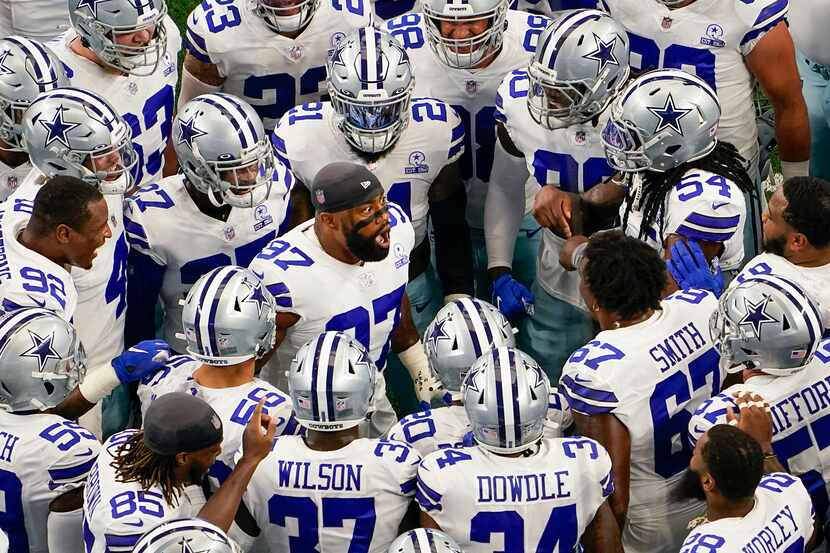 Dallas Cowboys players huddle around defensive end Everson Griffen (97) before an NFL...