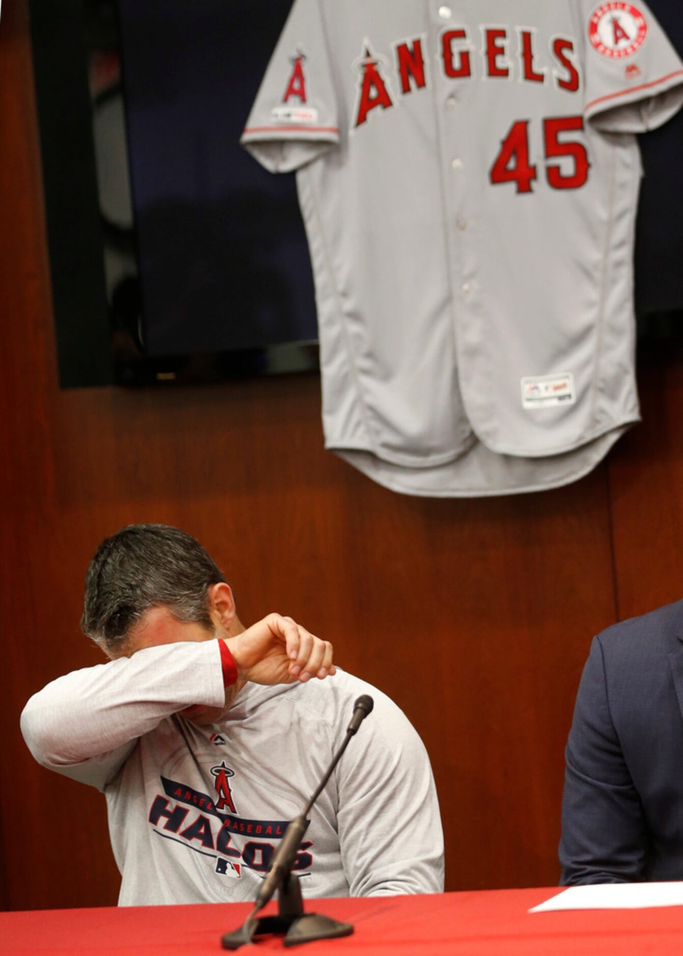 Los Angeles Angels manager Brad Ausmus wipes away tears as he answers questions during a...