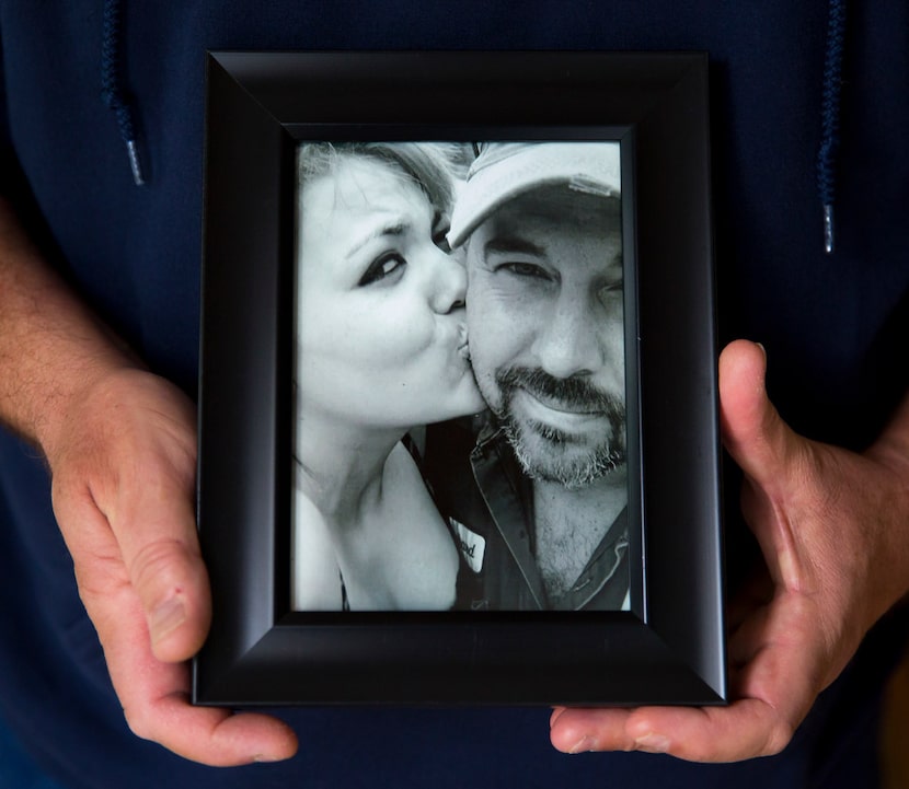 Richard Ford holds a framed photo of him with his daughter, Desiree, in his home in Cypress...