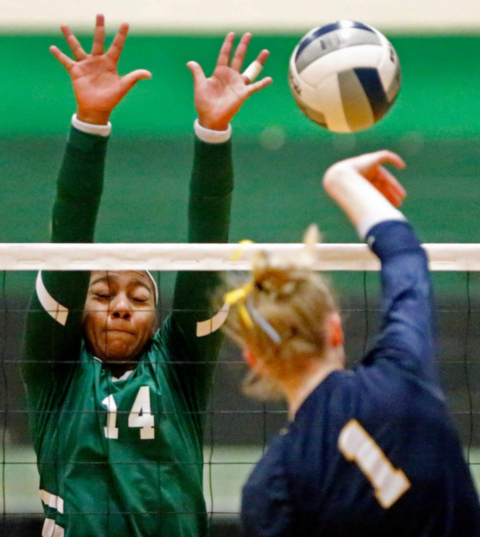 Highland Park High School middle hitter Avery Hellmuth (1)  tries to get a hit past Lebanon...