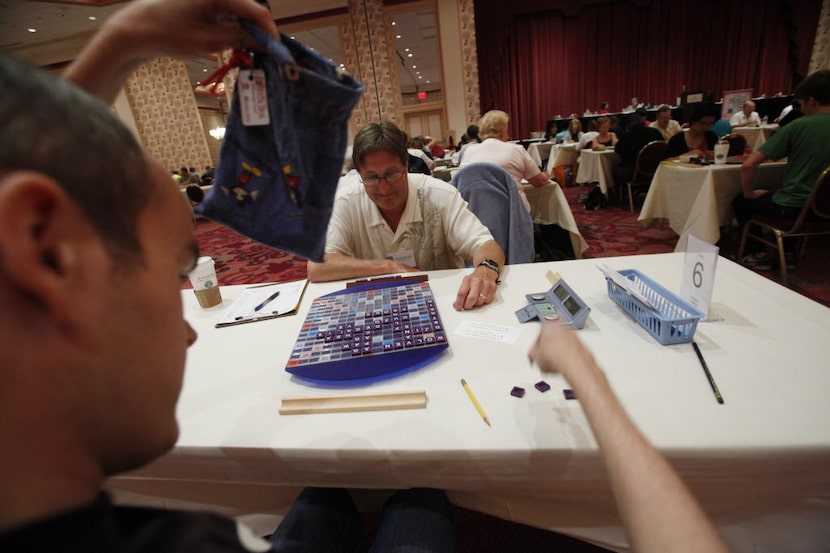 Wes Eddings pulls letters from a scrabble bag during his game against Chuck Riordan during...