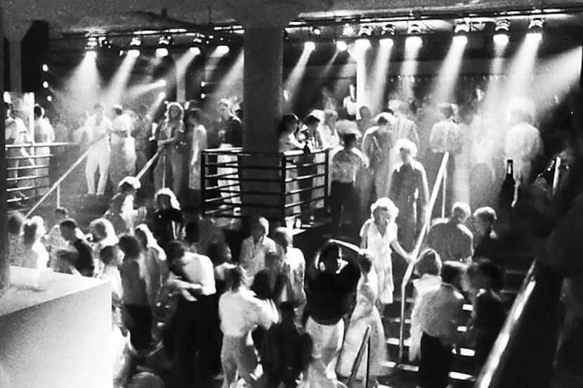 Patrons dance under red lights on the stairs at the Starck Club in Dallas in August 1985.