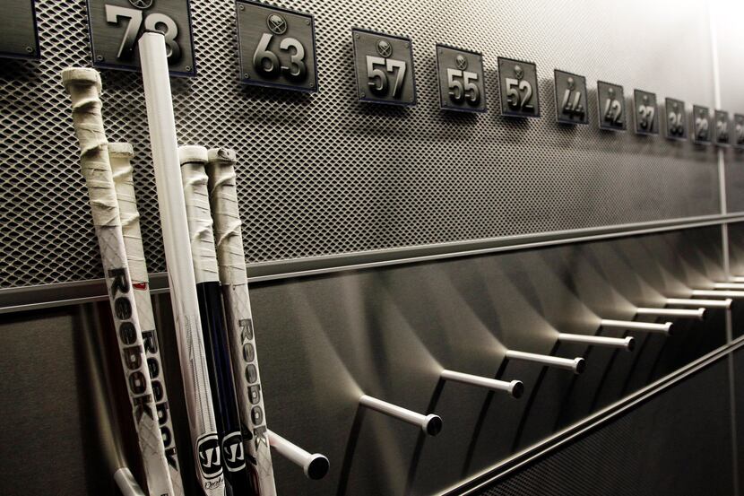 FILE - In this Sept. 25, 2012 file photo,  a nearly empty hockey stick rack in the locker...