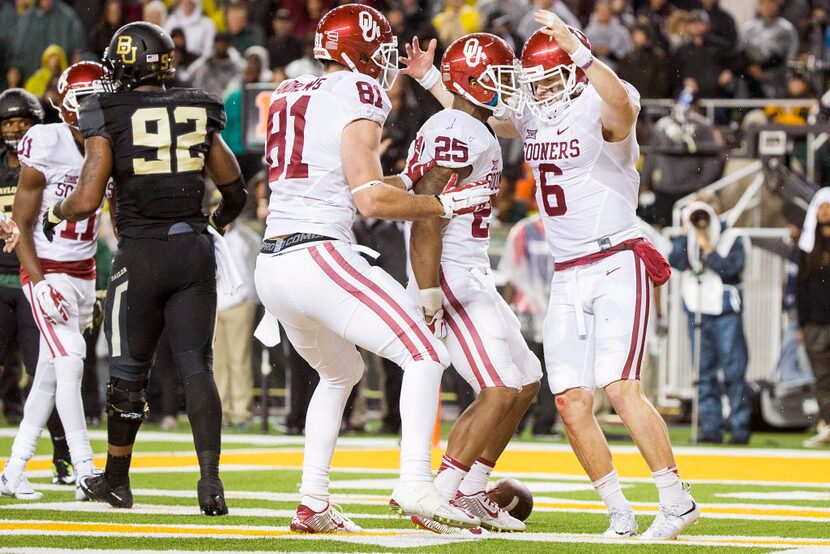 Oklahoma Sooners quarterback Baker Mayfield (6) celebrates with running back Joe Mixon (25)...