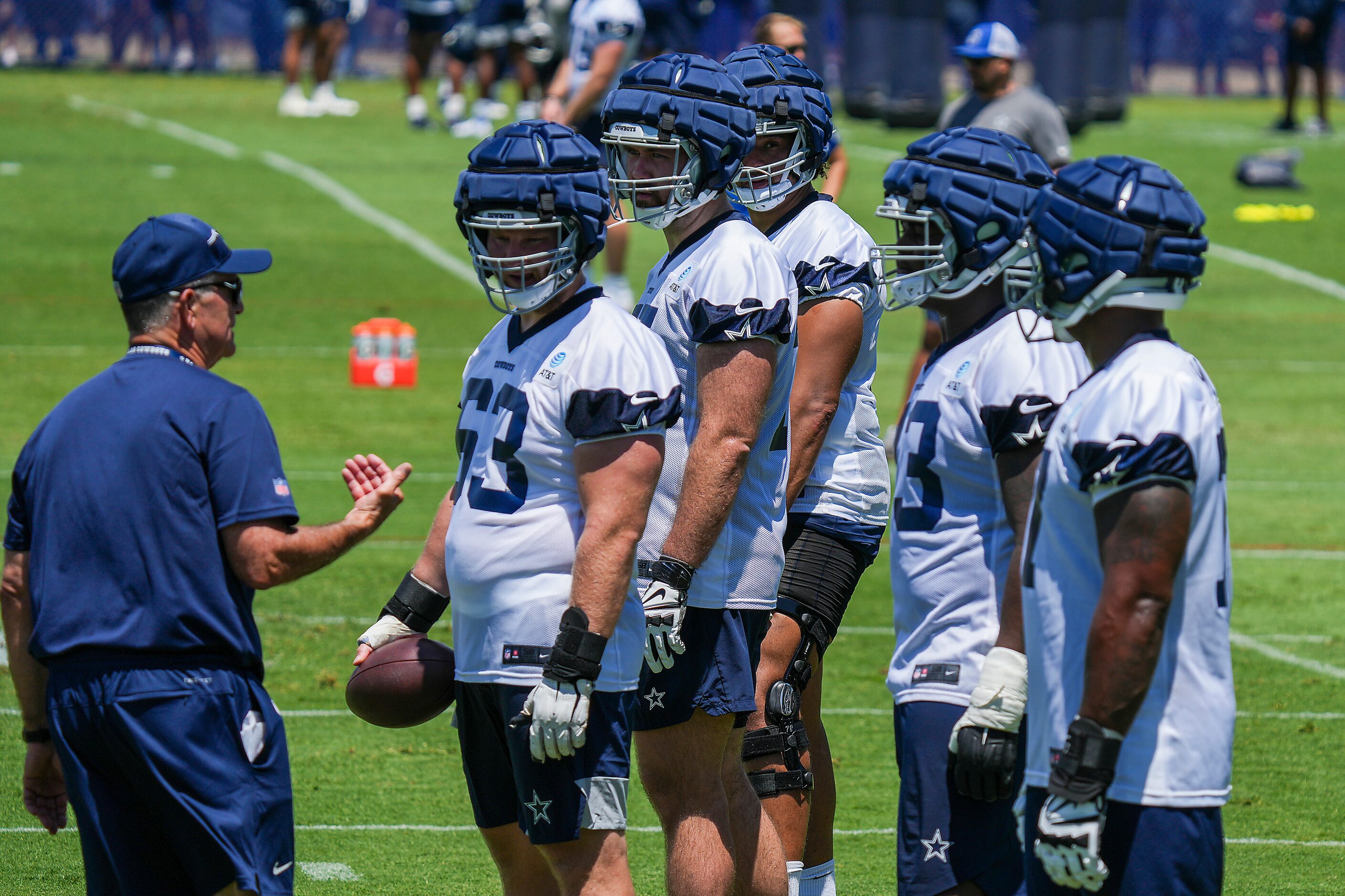 Dallas Cowboys offensive line coach Mike Solari talks with linemen (from left) Tyler Biadasz...