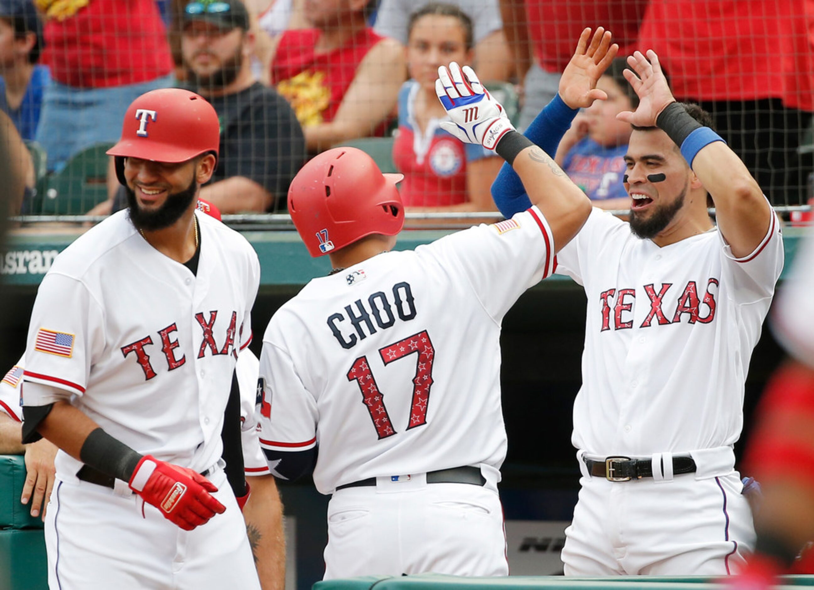 Texas Rangers' Shin-Soo Choo (17) is congratulated by Nomar Mazara, left, and Robinson...