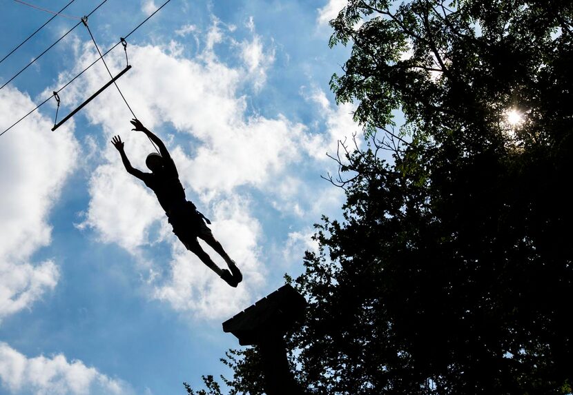 
Eduardo Nery, 18, jumps from the top of a pole to a bar hung by wires at Camp I-Thonka-Chi...