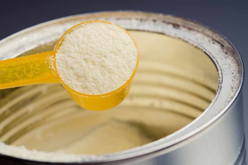A close-up of baby formula powder in a can.