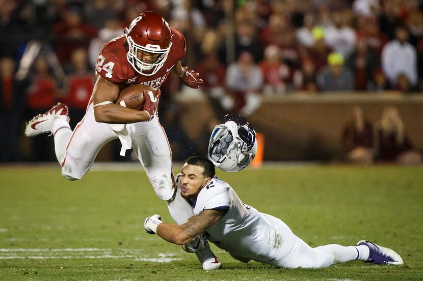 TCU safety Niko Small (2) has his helmet knocked off as he tries to bring down Oklahoma...