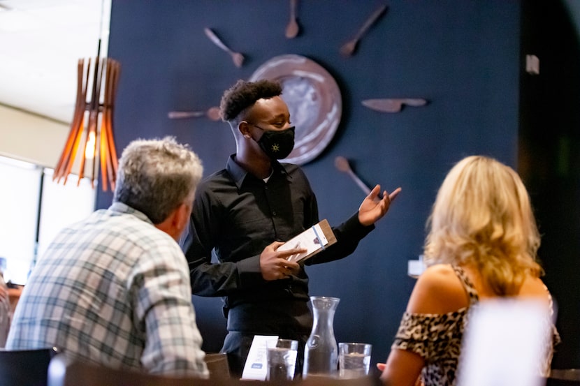 Seventeen-year-old Darrion takes food orders from Richard McCauley and Tara Williams at Café...