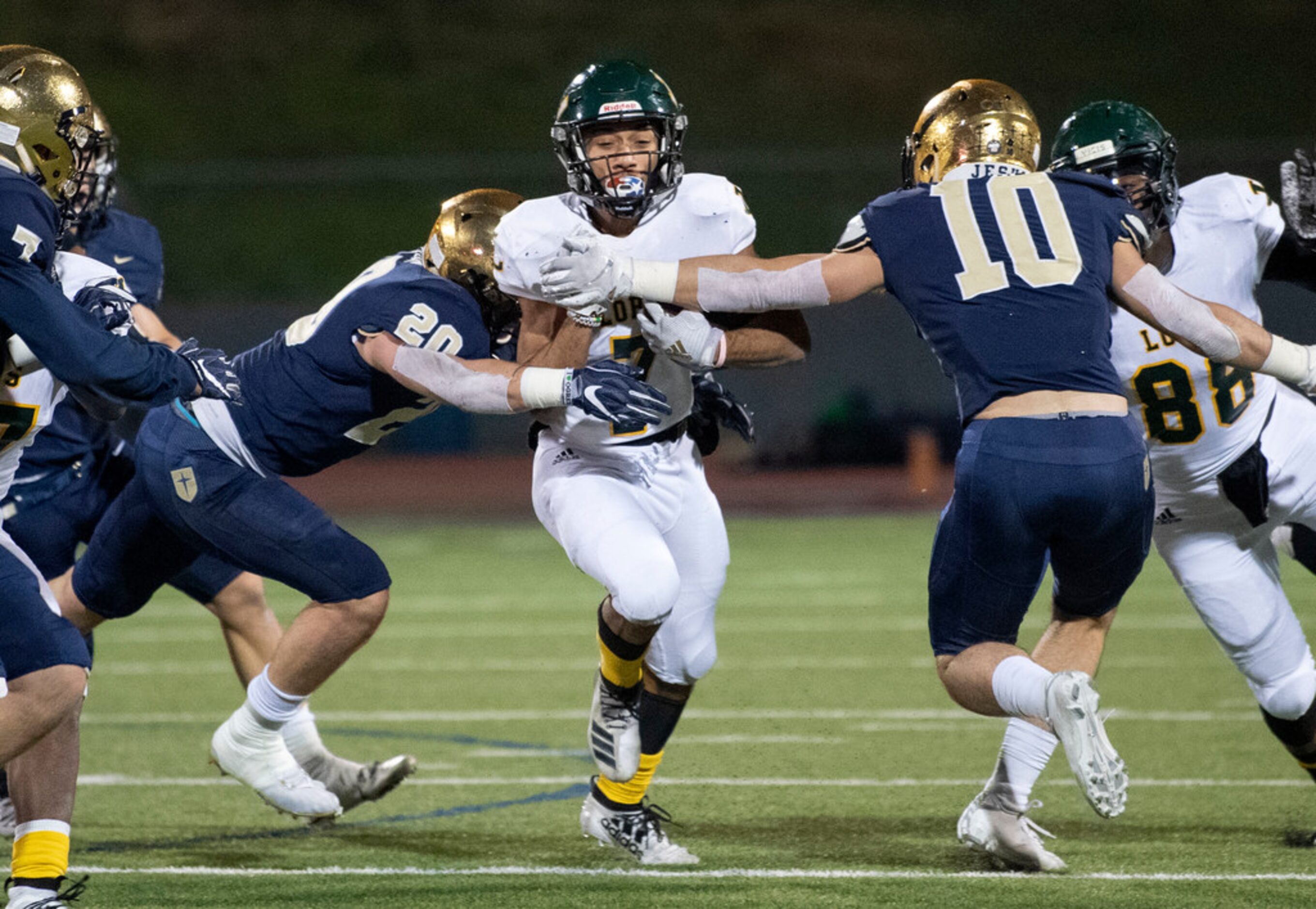 Longview junior running back Kaden Meredith (7) is tackled by Jesuit senior defensive back...