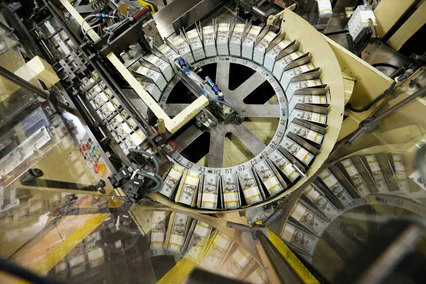 Stacks of $100 bills go through the production line at the Bureau of Engraving and Printing...