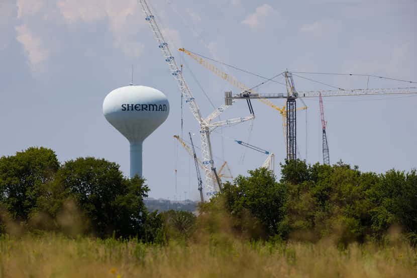 Sherman's water tower is accompanied by cranes erecting Texas Instruments’ two new chip...