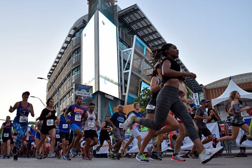 Runners leave the starting line to kick-off the 2018 Mavs Run This Town 5k outside of the...