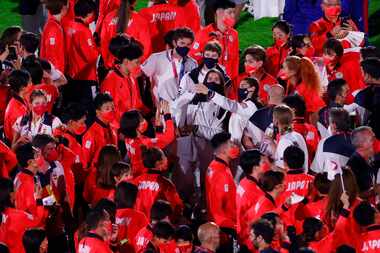 USA athletes take photos with athletes from Japan and others during the closing ceremony at...
