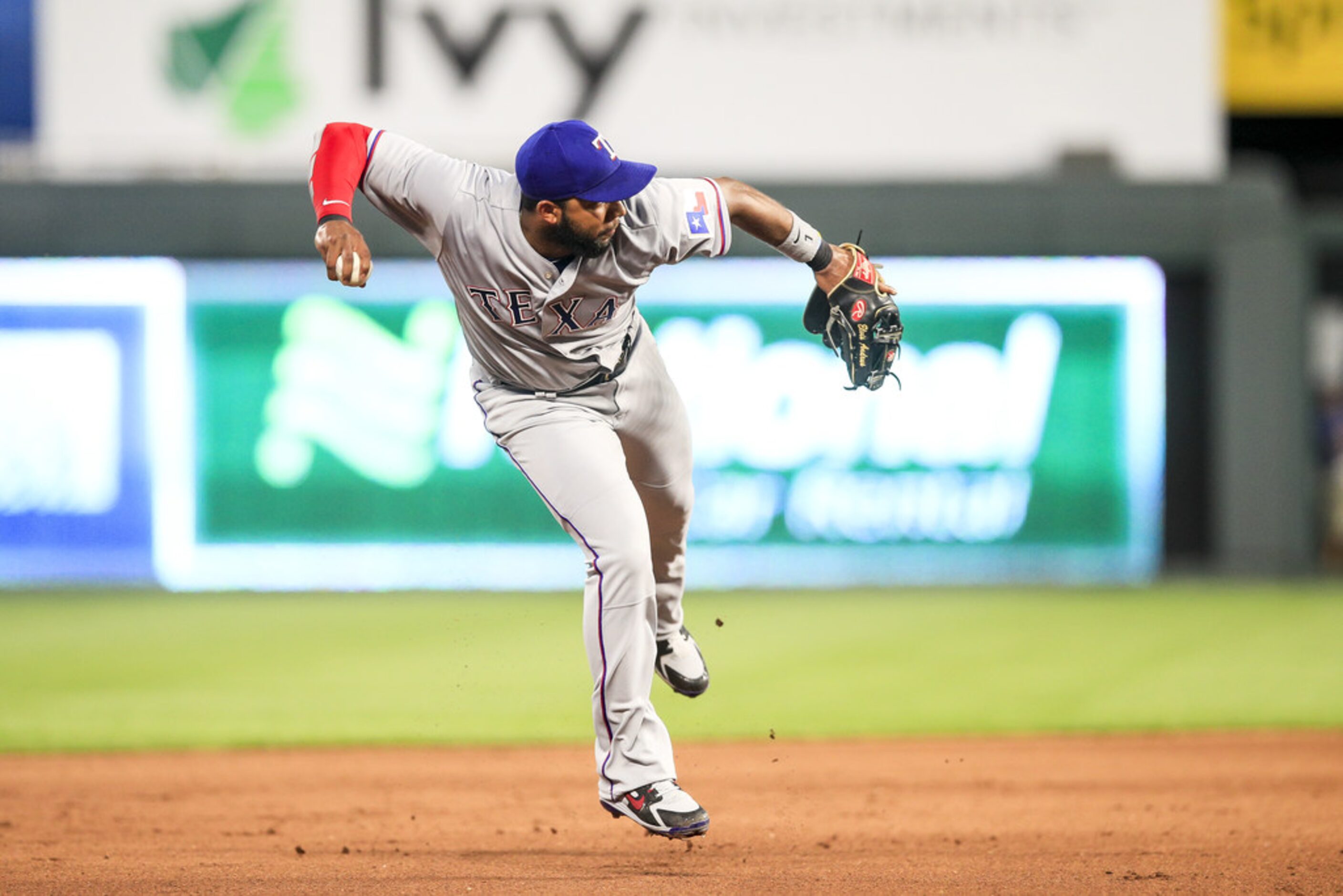 KANSAS CITY, MO - JUNE 18: Elvis Andrus #1 of the Texas Rangers attempts a throw to first...