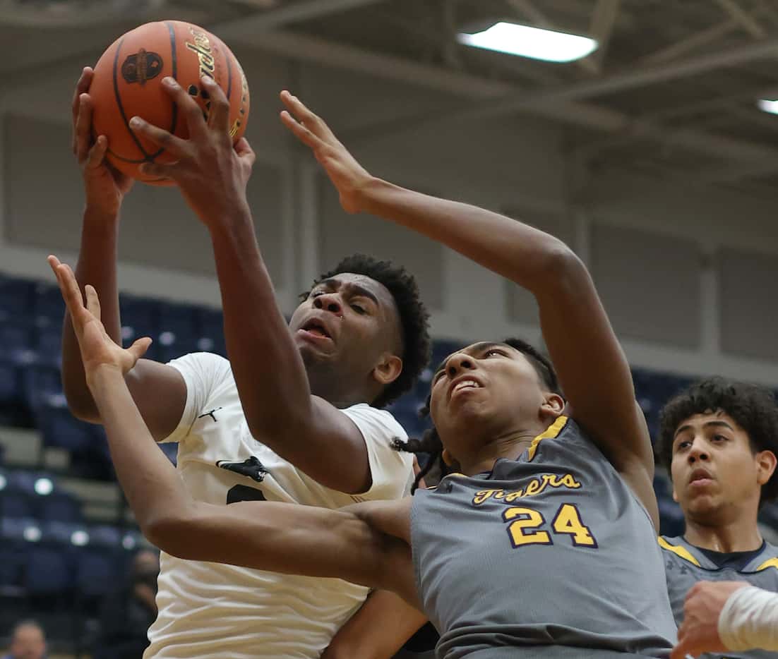 Plano East forward DJ Hall (0), left, pulls down an offensive rebound as he battles with...