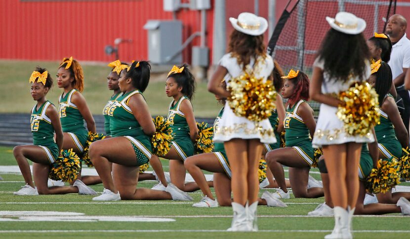 DeSoto cheerleaders take a knee during the playing of the national anthem before the DeSoto...