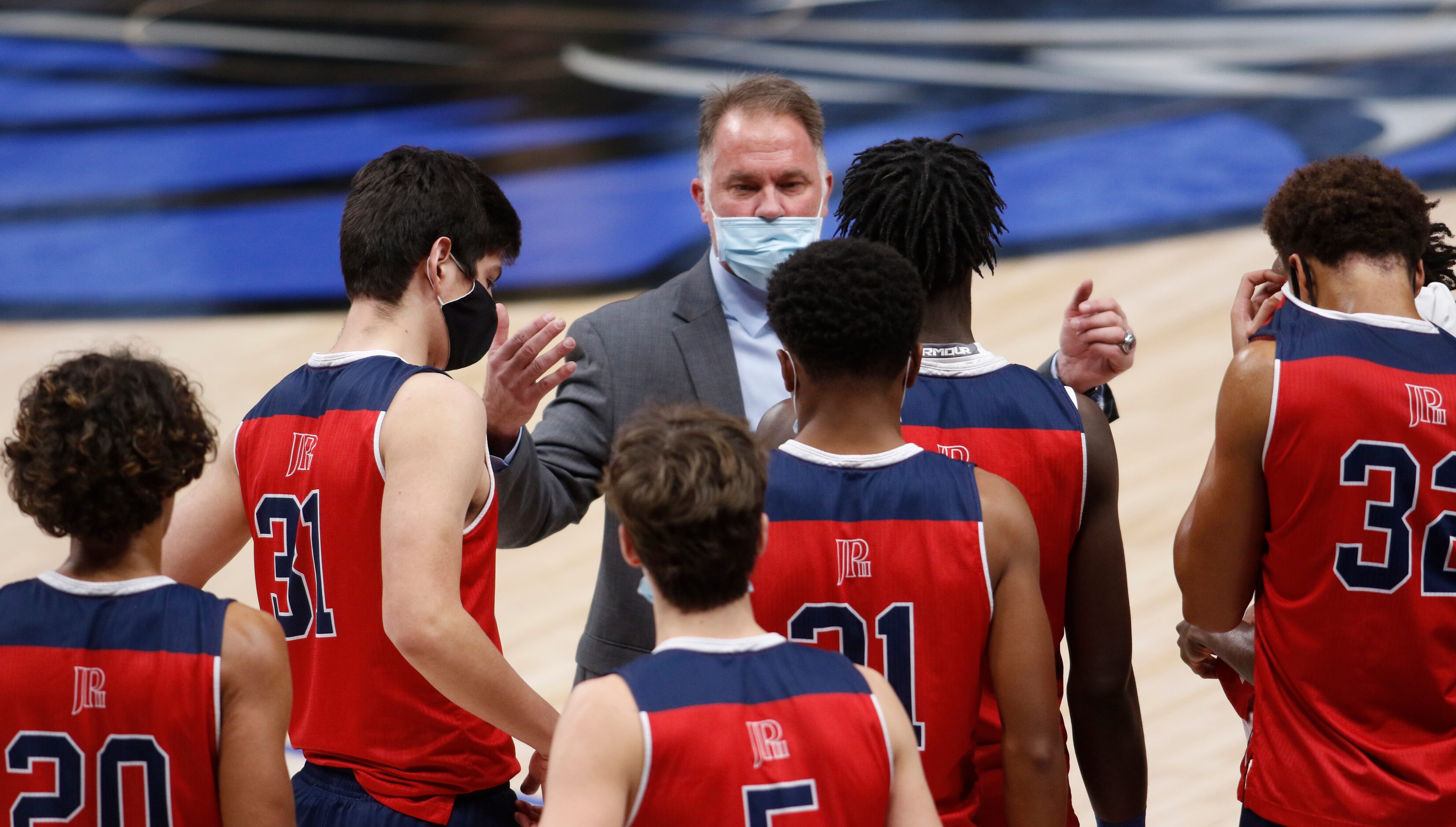 Plano John Paul ll head coach Dan Lee speaks with his players following their 61-56 victory...