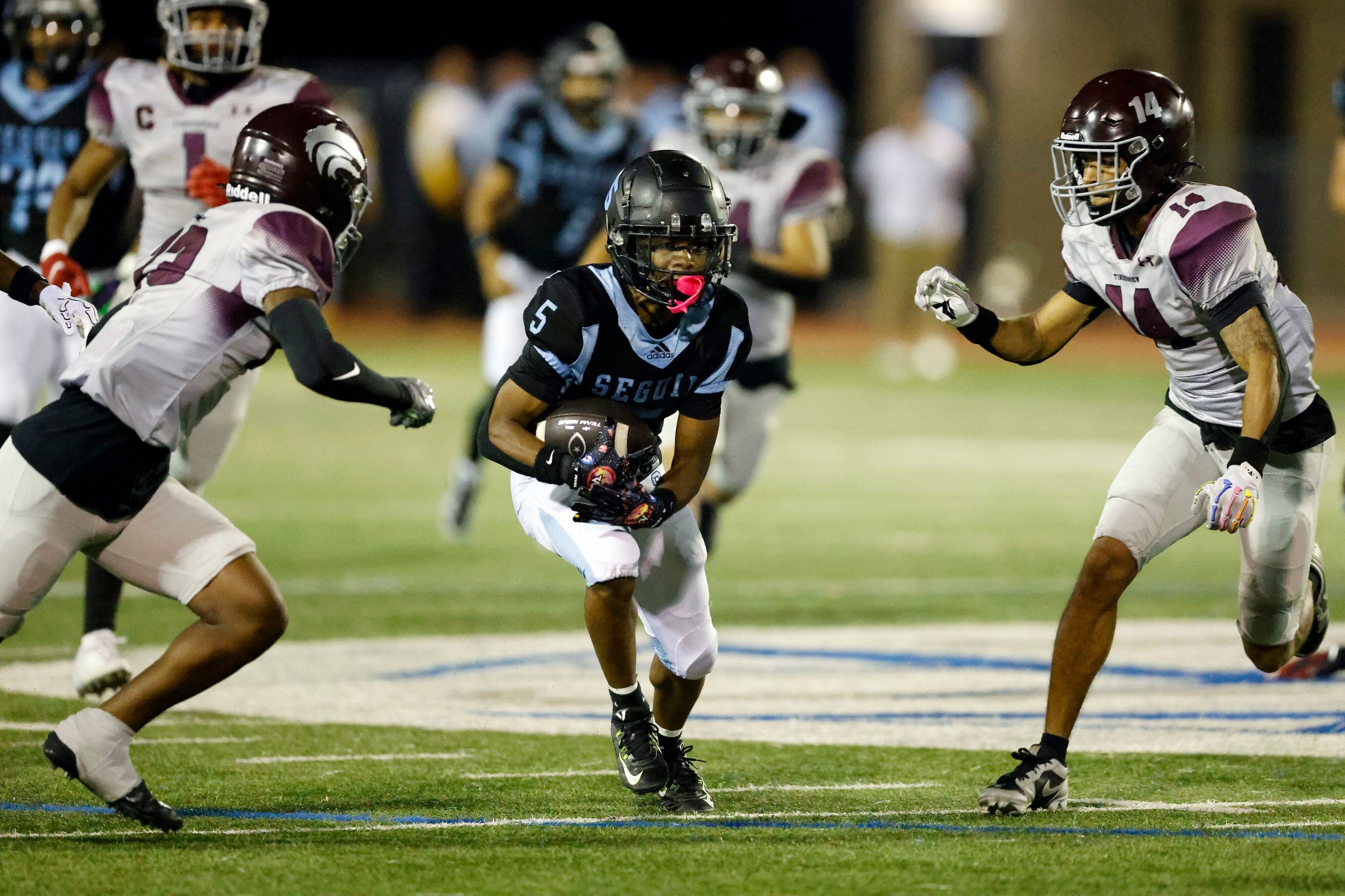 Arlington Seguin wide receiver Malachi Meche (5) runs the ball past Mansfield Timberview...