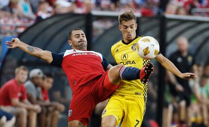 FC Dallas defender Marquinhos Pedroso, left, clears the ball away from Columbus Crew...