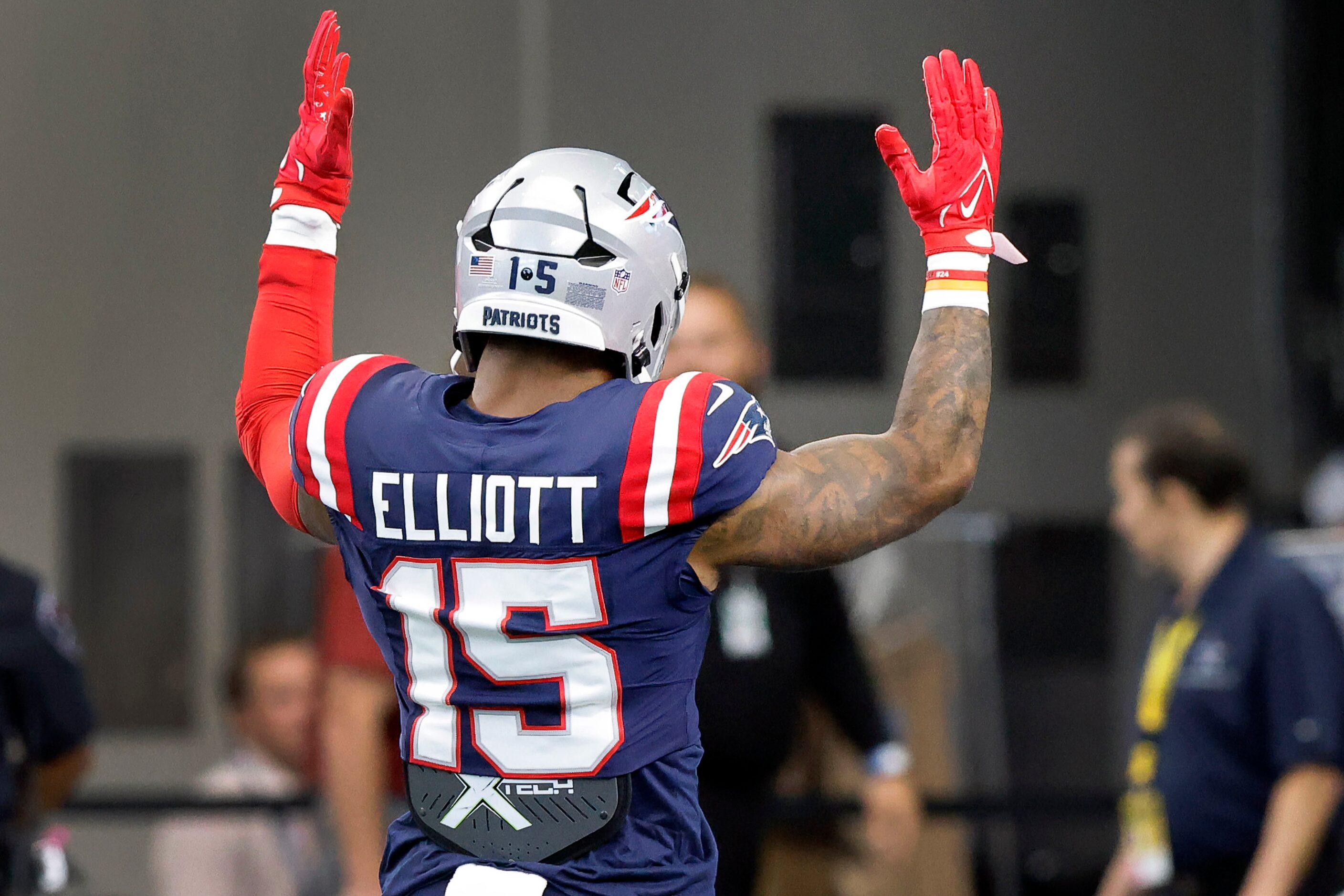 New England Patriots running back Ezekiel Elliott (15)  raises his hands to the crowd during...