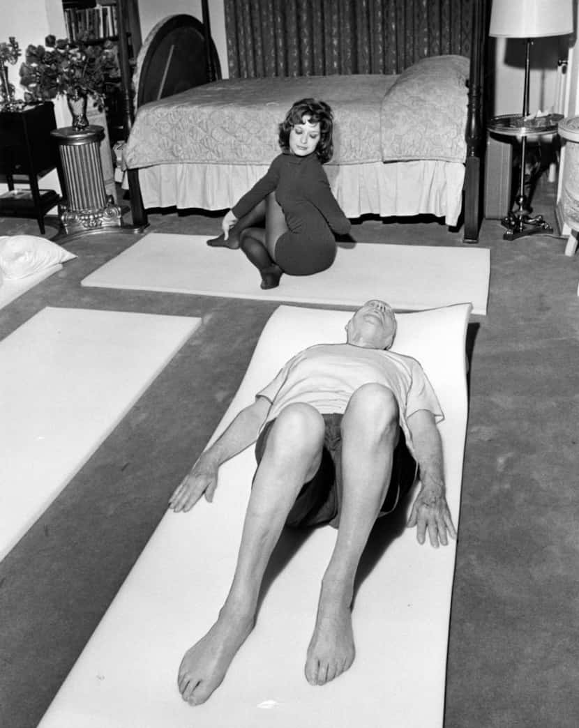 Hunt practices yoga as secretary Paula Lindsey watches.