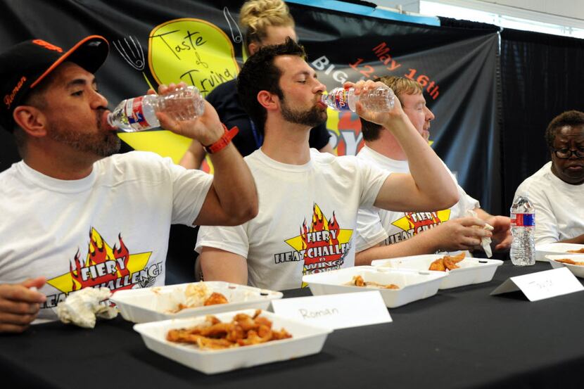 Contestants drink water after eating wings by Wing Town at the Taste of Irving Fiery Heat...