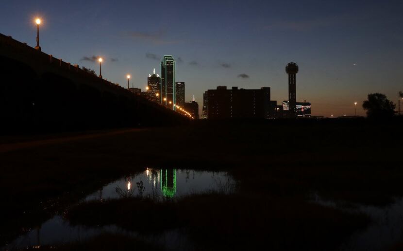 Reunion Tower (right) stood with the lights out as the sun rose over downtown Dallas on...