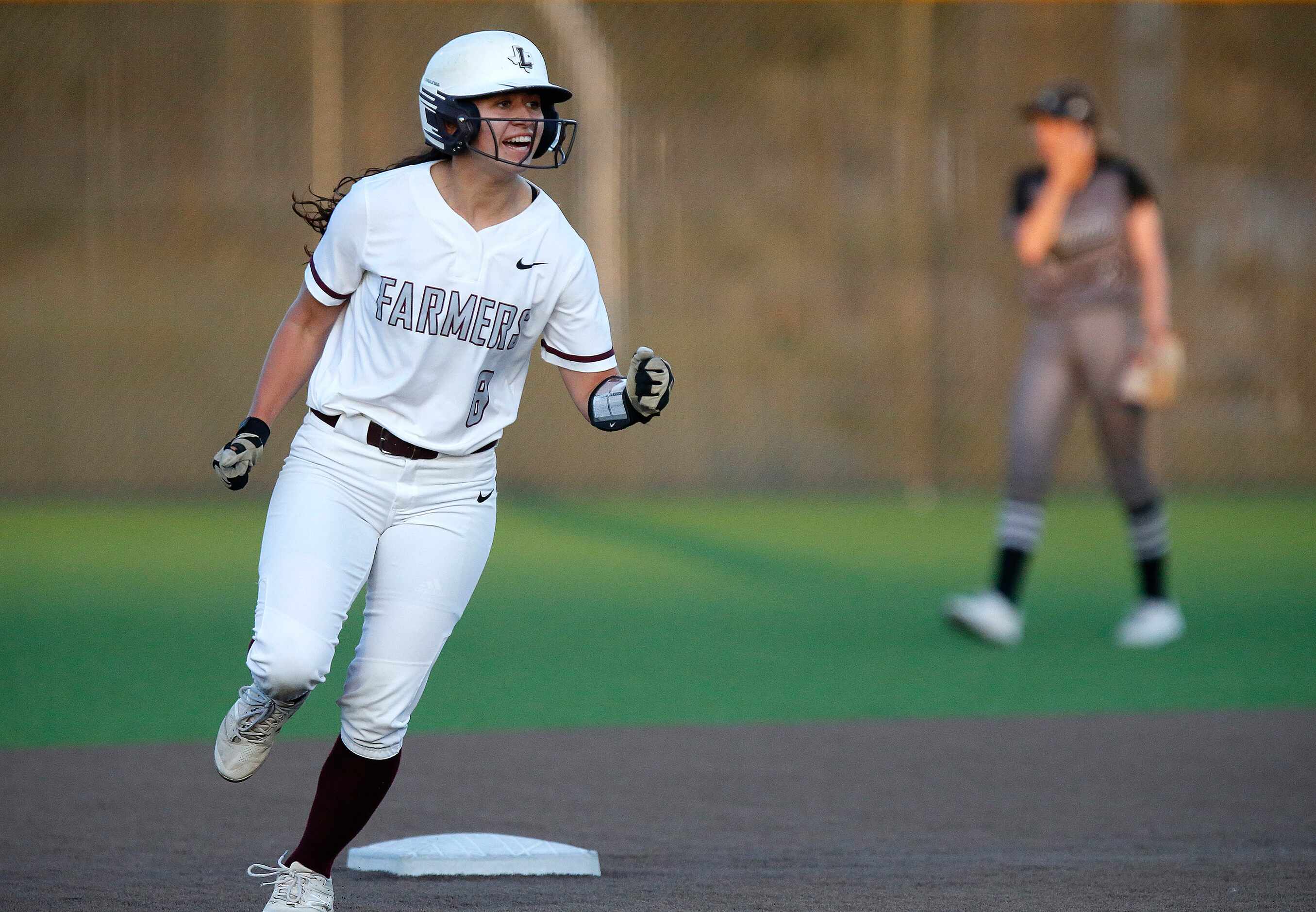 Lewisville High School left fielder Rylee Brice (8) reacts as she round second base on a...