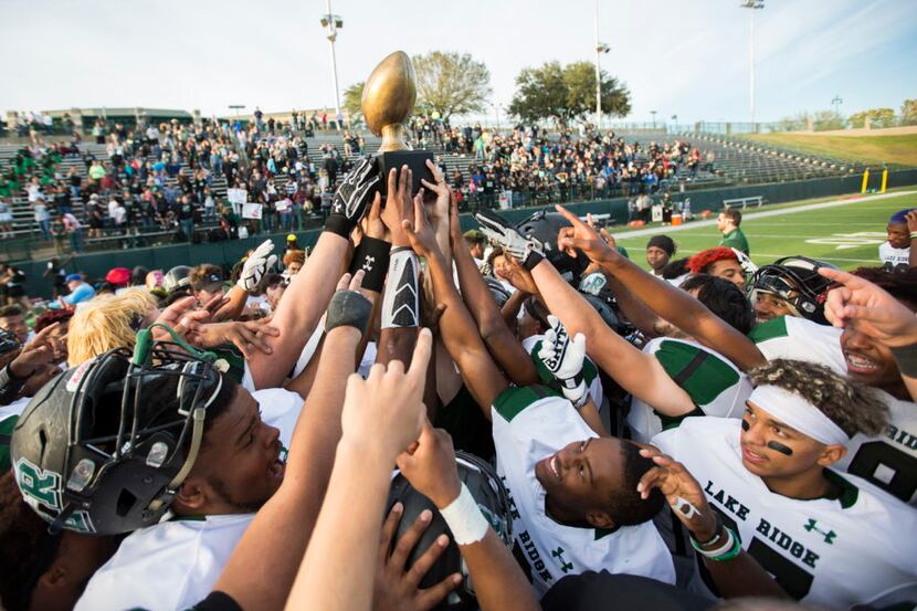 Lake Ridge celebrates with their trophy after a Class 5A Division 1 area-round playoff...