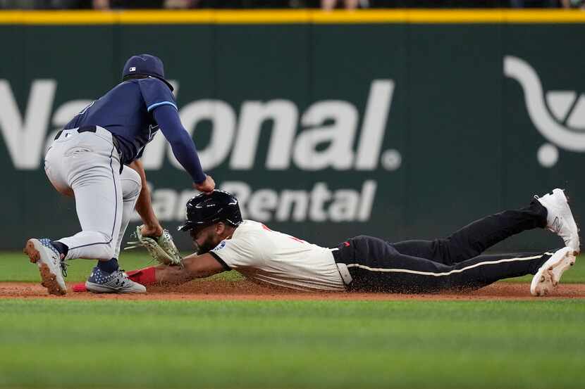 Texas Rangers Leody Taveras, right, is tagged out while trying to steal second base against...