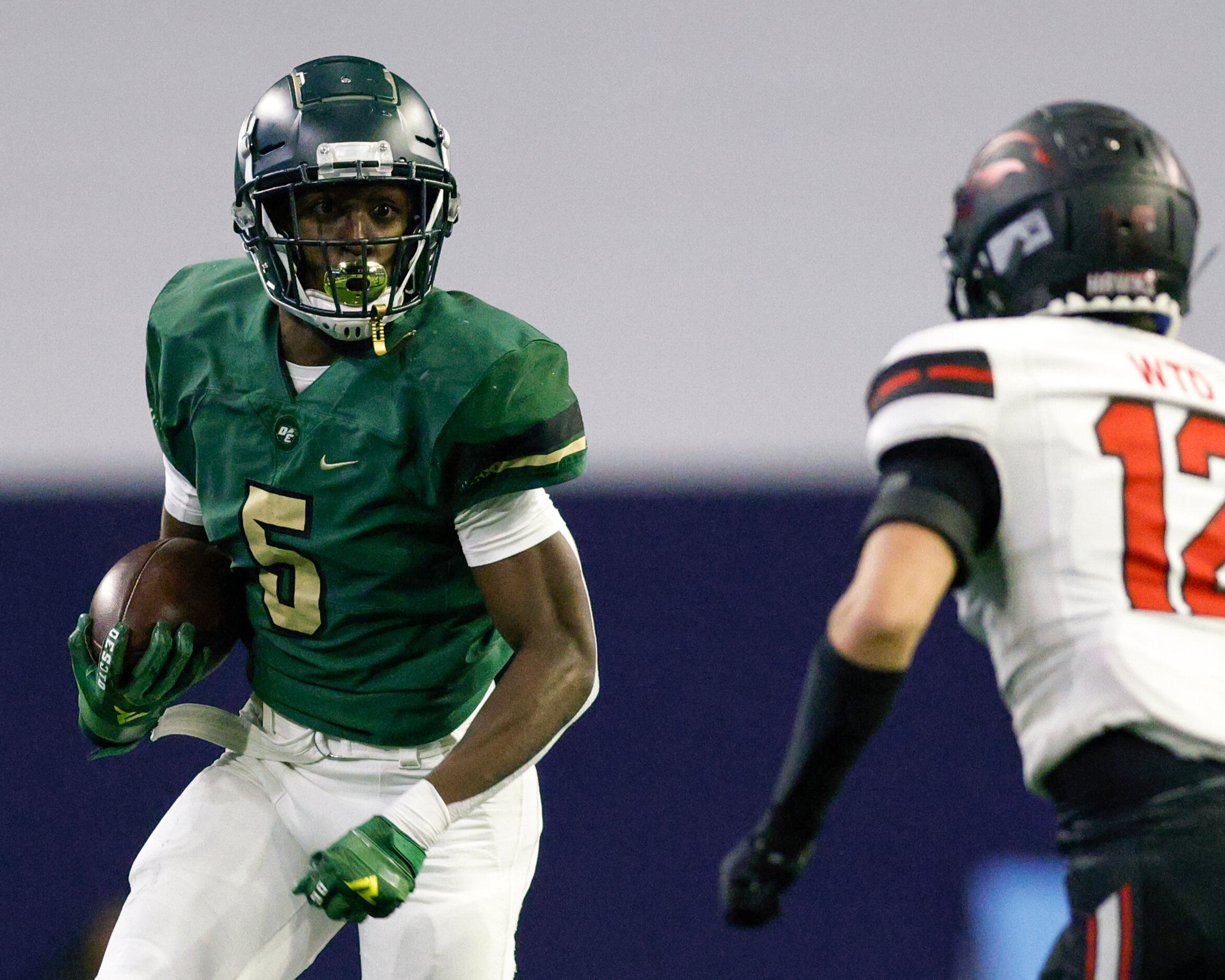 DeSoto’s Tre Wisner (5) runs at Rockwall-Heath’s Stosh Whisenant (12) during the first half...