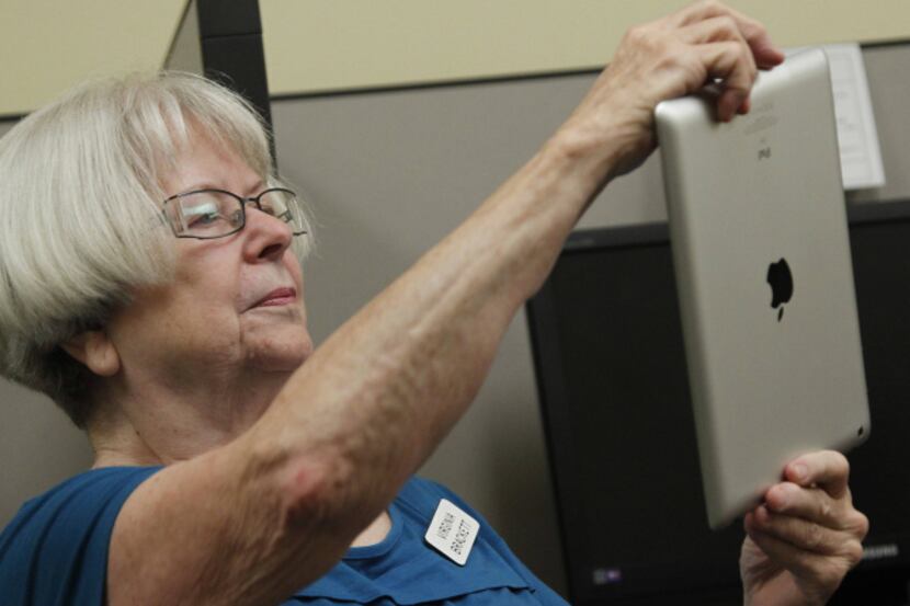 Virginia Brackett , 75, practices using the camera app. Her instructor, Tressa Reyes, has...