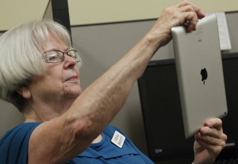 Virginia Brackett , 75, practices using the camera app. Her instructor, Tressa Reyes, has...