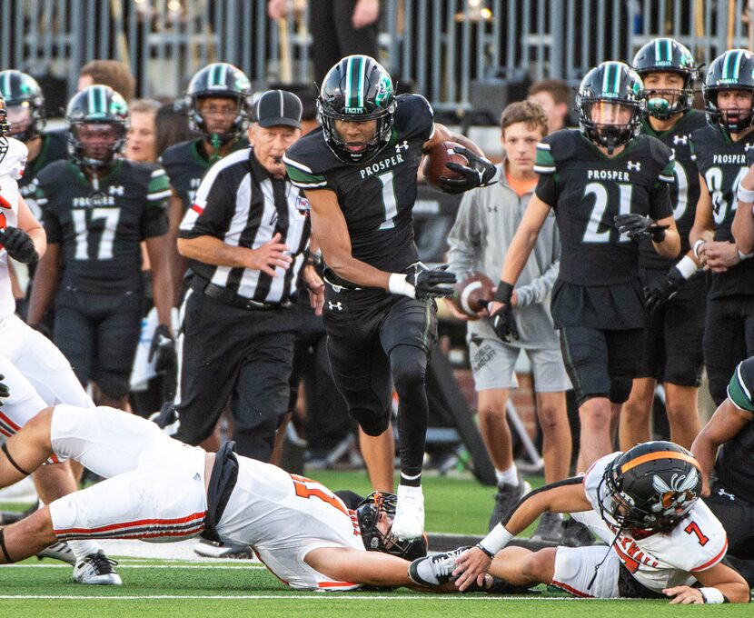 Prosper's Hunter Summers (1) runs between tackle attempts by Rockwall free safety Jake...