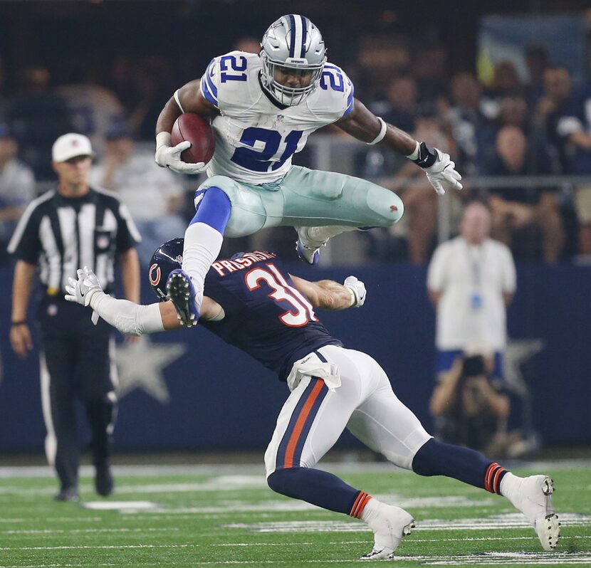 Dallas Cowboys running back Ezekiel Elliott (21) leaps over Chicago Bears strong safety...