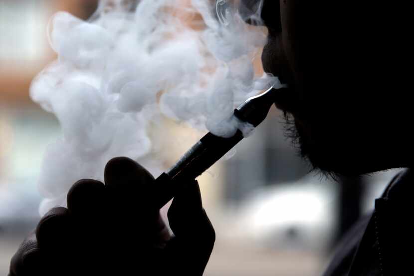 
A vaper puffs away on a battery-operated nicotine stick. Electronic cigarettes can save...